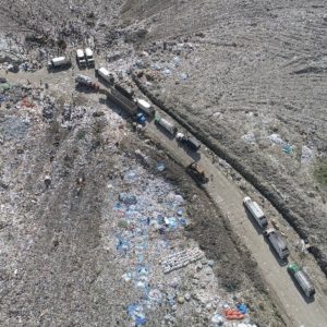 Trucks depositing trash into landfill